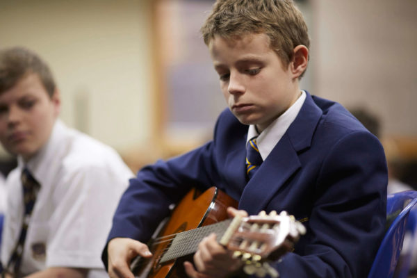 Senior School student practicing his guitar during a music class